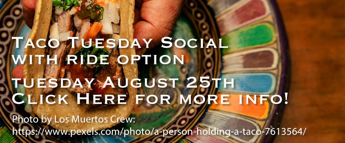 Background image of a hand holding a taco above a plate on the wooden table with white type overlaying it saying Taco Tuesday Social on the first line with ride option on the second line and Tuesday August 25th on the third line and Click here for more info! on the fourth line and Photo by Los Muertos Crew: on the fifth line and https://www.pexels.com/photo/a-person-holding-a-taco-7613564/ on the sixth line.